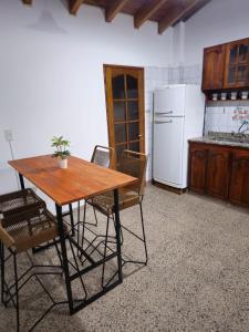 uma cozinha com uma mesa e cadeiras e um frigorífico em La Primi em Guaymallén