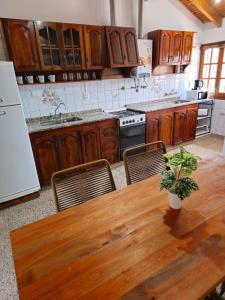 a kitchen with a wooden table with chairs and a refrigerator at La Primi in Guaymallen