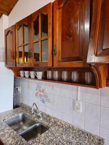 uma cozinha com um lavatório e armários de madeira em La Primi em Guaymallén