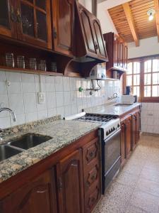 uma cozinha com armários de madeira e um forno com placa de fogão em La Primi em Guaymallén