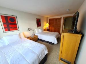 a hotel room with two beds and a flat screen tv at Northwoods Ski In Ski Out Access in Vail +9 photos