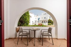 纳克索乔拉Naxos Resort by Icon Blue的有窗户的房间里有一张桌子和几把椅子