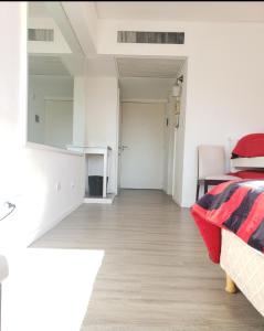 a living room with a bed and a wooden floor at Casa Cúpulas de la Ciudad in Buenos Aires