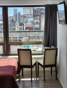 Pokój ze stołem, 2 krzesłami i oknem w obiekcie Casa Cúpulas de la Ciudad w BuenosAires