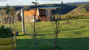 una pequeña cabaña en un campo con una casa en Cabaña en el campo, en Tacuarembó