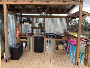 an outdoor kitchen with a wooden deck with a bar at Tiki Cabana in Hawaiian Ocean View