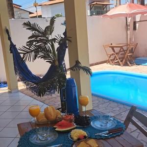 un tavolo con cibo e bevande accanto a una piscina di Pousada Praia do Francês a Praia do Frances