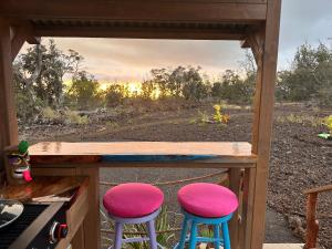 two pink and blue stools sitting on a porch at Tiki Cabana in Hawaiian Ocean View