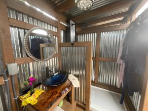 ein Bad mit einem Waschbecken und einem Spiegel in der Unterkunft Tiki Cabana in Hawaiian Ocean View