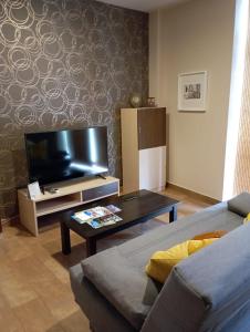 Apartamento Duquesa في روت: غرفة معيشة مع أريكة وتلفزيون بشاشة مسطحة