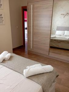 a bedroom with two towels on two beds and a mirror at Apartamento Duquesa in Rute