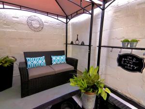 a porch with a couch and some potted plants at Hugh's and Nora's Place to stay in Brooklyn