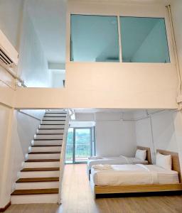 una camera con due letti e una scala con finestra di The Ventus Phangan Loft Apartments a Haad Rin