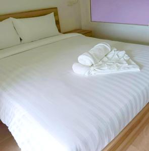un letto bianco con lenzuola e cuscini bianchi di The Ventus Phangan Loft Apartments a Haad Rin