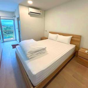 un letto bianco in una stanza con finestra di The Ventus Phangan Loft Apartments a Haad Rin