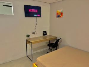 een kamer met een bureau en een televisie aan de muur bij Citadin Yurrita in Guatemala