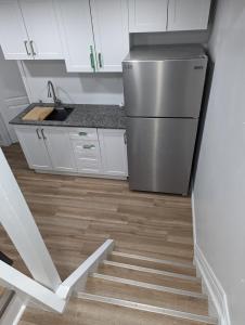 a kitchen with a stainless steel refrigerator and wooden floors at House of Pleasantness in Hamilton