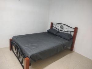 Una cama con marco de metal y almohadas. en Departamento en Campeche estación del tren maya, en Campeche