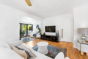 a living room with white walls and a white couch at Villa Del Mar - Belle Escapes Jervis Bay in Vincentia