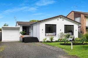 a white house with a garage at Villa Del Mar - Belle Escapes Jervis Bay in Vincentia