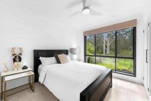 a bedroom with a bed and a large window at Villa Del Mar - Belle Escapes Jervis Bay in Vincentia +15 photos