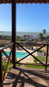 a view of a pool from a balcony with the ocean at Pousada Makai - Cajueiro da Praia in Barra Grande