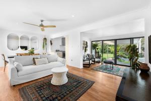 a living room with a white couch and a table at Villa Del Mar - Belle Escapes Jervis Bay in Vincentia