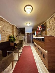 un soggiorno con tappeto rosso e divano di Motel Atika a Skopje
