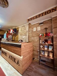 a reception area of a restaurant with a sign on the wall at Motel Atika in Skopje