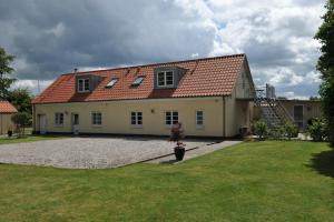 una casa amarilla con techo rojo y patio en Herning Bed & Breakfast en Herning