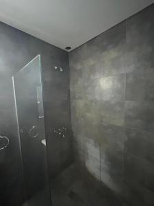 baño con ducha y puerta de cristal en Ohana Apartments (solo familias) en Villa Carlos Paz