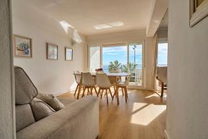 a living room with a couch and a table and chairs at Front Sea Line Experience in Fuengirola
