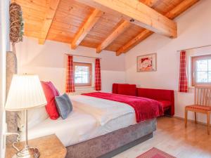 a bedroom with a bed and a red chair at Rosalie-Lorena in Ramsau im Zillertal