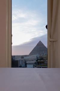 una finestra aperta con vista sulle piramidi di Sky Pyramids View Inn a Il Cairo