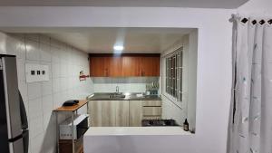 a small kitchen with a tub and a sink at Habita Living Bogotá in Bogotá