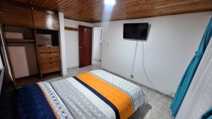 a bedroom with a bed and a tv on the wall at Habita Living Bogotá in Bogotá