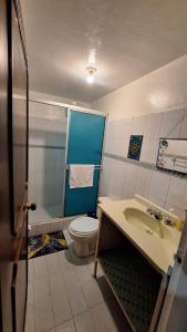 a bathroom with a toilet and a sink at Habita Living Bogotá in Bogotá