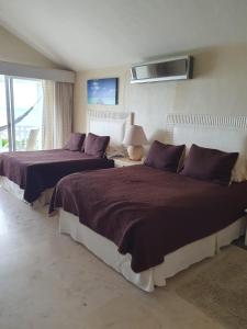 Banco Playa的住宿－Puerta del Mar Cozumel，一间卧室配有两张带紫色枕头的床