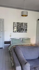 a bedroom with a bed with a painting on the wall at 16 Big Comfy Studio - Great Location - Free Onsite Parking - Comfy Bed in Brighton & Hove