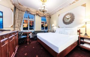 Hotel General Old Town Prague في براغ: غرفة نوم بسرير ومكتب ونافذة