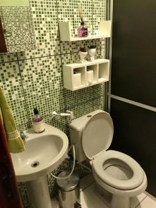 a bathroom with a toilet and a sink at Casa Rosa in Vale do Capao +9 photos