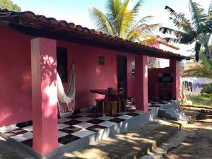 a red house with a black and white checkered floor at Casa Rosa in Vale do Capao