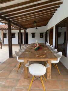 a long wooden table and chairs on a patio at Finca ganadera de lujo en el Quindío in Pueblo Tapao