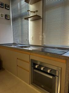 a kitchen with a sink and a stove at LOFTS CARIJOS CENTRO BH in Belo Horizonte