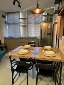 a kitchen with a table with chairs and a refrigerator at LOFTS CARIJOS CENTRO BH in Belo Horizonte