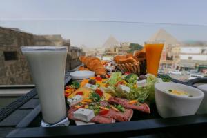 un vassoio con cibo e bevande su un tavolo di Sky Pyramids View Inn a Il Cairo