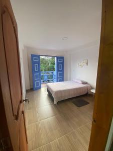 a bedroom with a bed and a door with a window at Apartahotel Villa Carolina 3 in Jericó