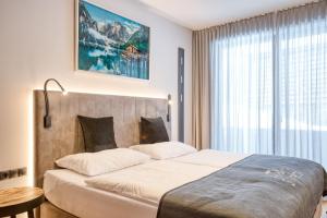 a bedroom with a large bed and a large window at Exklusiv und elegantes Apartment in der Residenz Silvretta - Inklusive Silvretta Card Premium in See