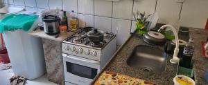 a small kitchen with a stove and a sink at Cantinho dos sonhos in Piúma