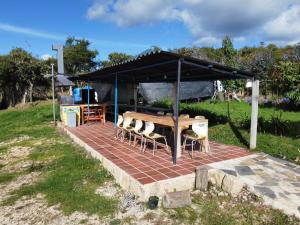 a patio with a table and chairs under a tent at Rancho New Life Guatavita in Guatavita